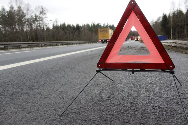 A warning triangle on the side of a highway.