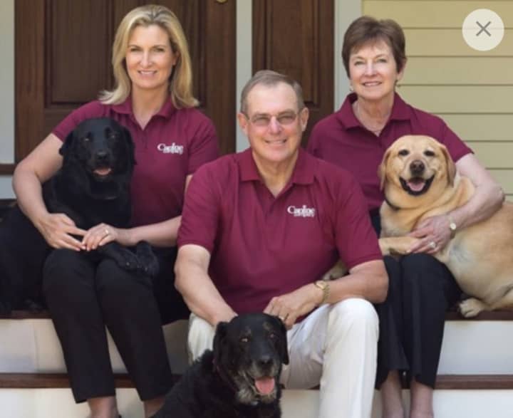 Jennifer Hill (left), president and CEO of Canine Company, with her parents, Henry and Carol Hill, who founded the company 30 years ago, along with a few of the family&#x27;s pets.