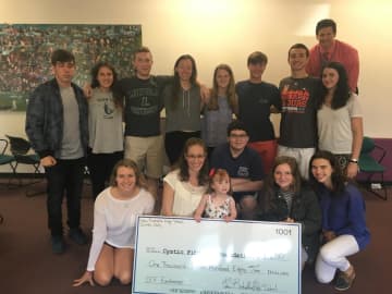The Irish Club pose with their fundraising check.