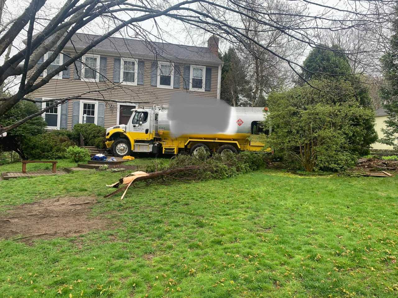 The oil truck in the yard of the home.