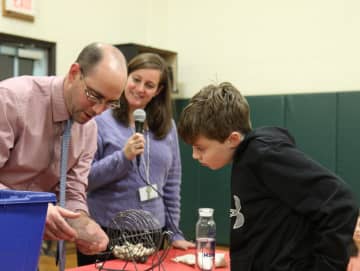 <p>Fourth grader Brendan Xanthos checks his winning Bingo card with Vice Principal Alex Harvey and Principal Paula Bleakley. </p>