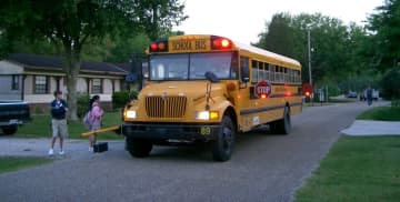 A school bus picks up kids.