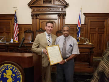 Brendan Gill (left), president of the Essex County Board of Chosen Freeholders, congratulates Willie Sumlar on his retirement. Sumlar has worked for the county for 62 years.