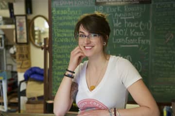 Redding Roasters Owner Kaitlyn Heisler, in front of a chalkboard filled with coffee choices.