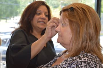 Teaneck salon owner Lillian Lee helps Patty, who has breast cancer, with her makeup before a wedding.
