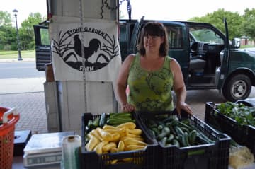 <p>Stacia Monahan from Stone Gardens Farm in Shelton sets up shop at the Shelton Farmers Market.</p>