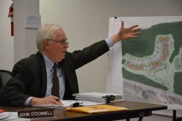 Lewisboro Planning Board member John O'Donnell gestures towards a layout sketch of a 46-unit affordable housing proposal for a site in Goldens Bridge