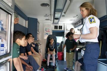 Kids from the Side by Side School in Norwalk get a tour of an ambulance as part of EMS Services Week.