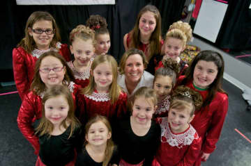 Dancers from the Kelly-Oster School of Irish Dance surround school owner Karyn Oster (center) prior to a recent performance.