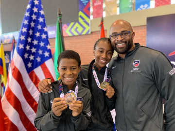 Greenwich brother and sister, Myles and Madison Ducket, with their father Richard Duckett, show the medals they won at the Pan American Youth Championships in Bolivia in August.