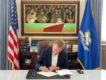 Ned Lamont signing a bill into law legalizing sports gambling.