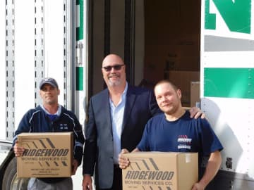 Daniel Weixeldorfer and employees from Ridgewood Moving help deliver food donations to Center for Food Action locations.