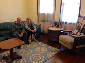 A married couple sits in their newly furnished home provided by Making-It-Home.