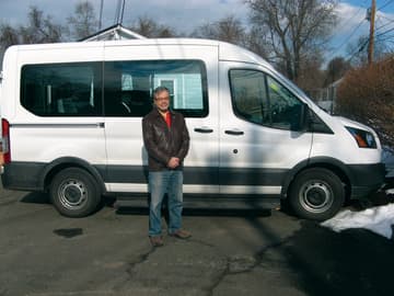 Gary Felberbaum of Trumbull, co-president of the Probus Club of Greater Bridgeport, stands by the new seven-passenger van the club donated to Kennedy Center clients who live at the Probus House in Bridgeport.