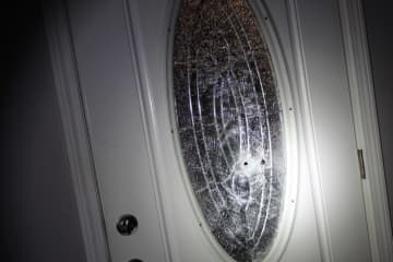 Damage to the home's front door during a drive-by shooting.