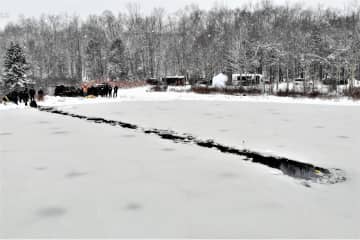Police divers cut a path through the ice to reach the victims.