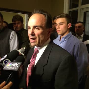 Joseph Ganim speaks with reporters after declaring victory in the Bridgeport mayoral race as his son, 18-year-old Joseph, looks on.