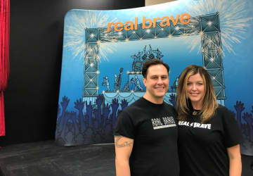 Daniel and Melissa Powers stand in front of the stage at Real Brave in Oakland.
