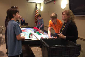 Ringwood teacher Ellen Gay, at right, helps her students set up their Lego robotics display at the library Thursday, Jan. 14.
