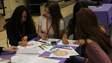 Dumont High School students unwind stress with coloring books.
