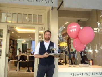 Adam Gold welcomes shoppers to Stuart Weitzman with a refreshing beverage during the Go For Pink! fundraiser, Thursday, Oct. 6, 2016.