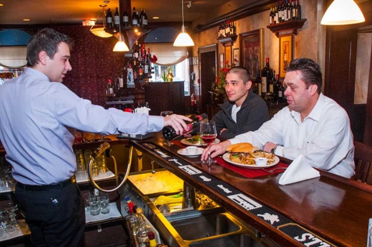 Sapore Steakhouse's general manager pours a little vino for two of the chefs at the Fishkill eatery.