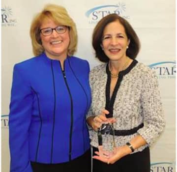 Katie Banzhaf, executive director of STAR, Inc. (left) presents the “Humanitarian of the Year” award to State Representative Gail Lavielle.