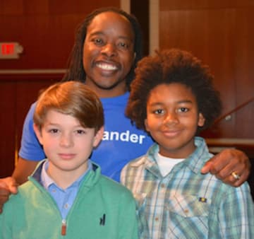New Canaan Country School sixth graders Byrne Matthews, left, of Norwalk and Mason Pratt of Trumbull with guest speaker, author, rapper and university professor, Dr. Omékongo Dibinga, at an assembly honoring Martin Luther King Jr.