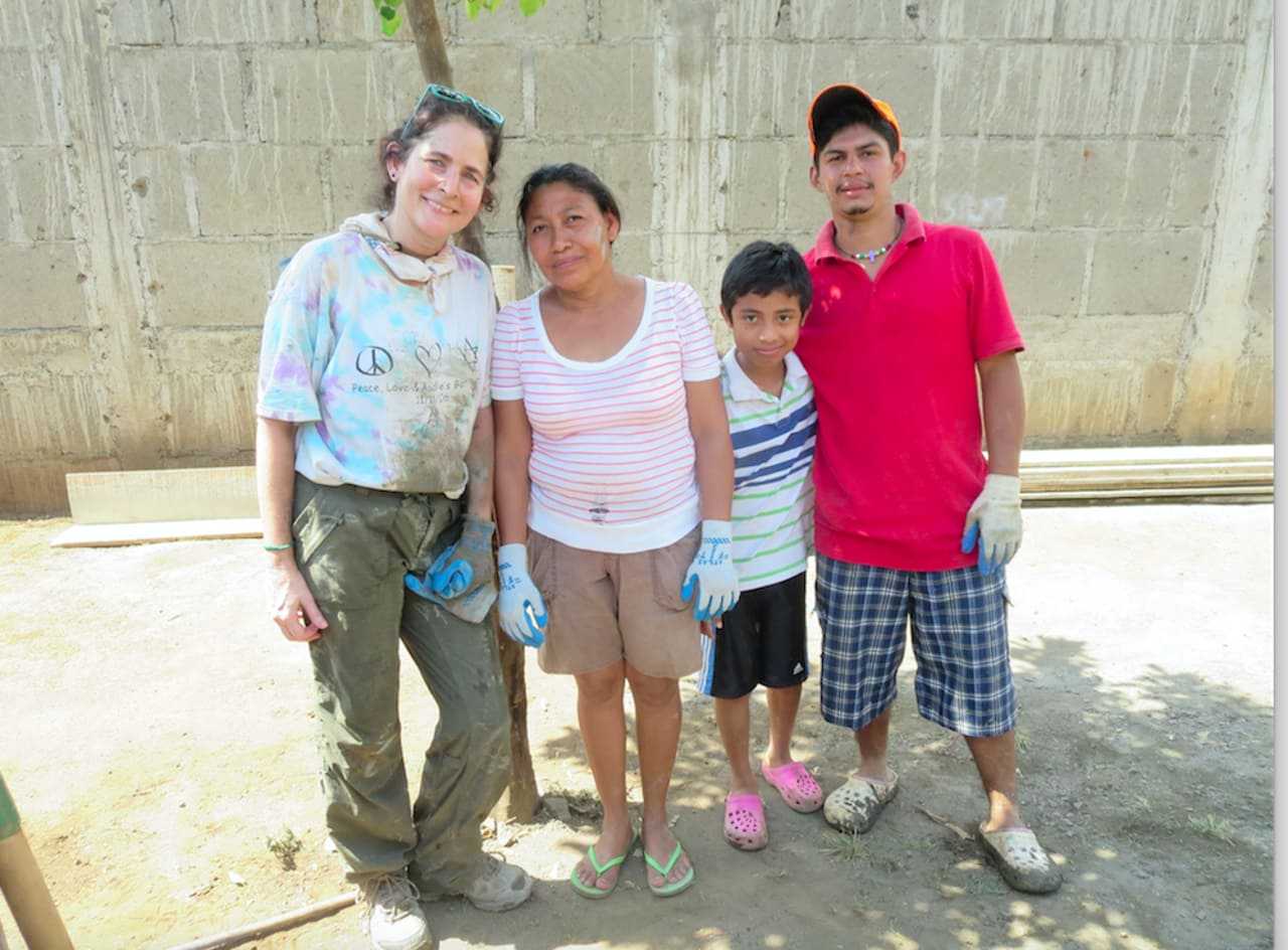 Newtown resident Diane Sarna, posing with a family whose home she helped to build in Nicaragua.