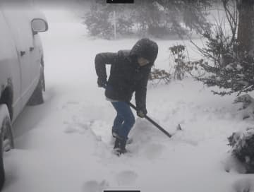 12-year-old Hannah McGuire shoveling snow in her Bethel driveway.