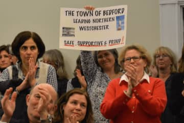 Residents give applause after the Bedford Town Board adopted a resolution on immigration policy.