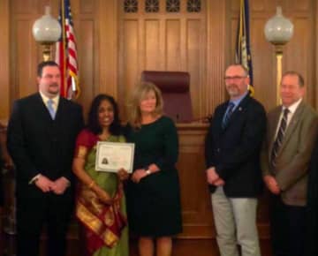 One of Putnam County's new citizens being congratulated by County Executive MaryEllen Odell, Sheriff Robert Langley and other elected officials at a recent ceremony.