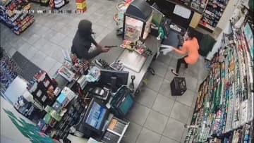 <p>A man is seen pointing a gun at a clerk during the robbery of a Bloomfield gas station last week</p>