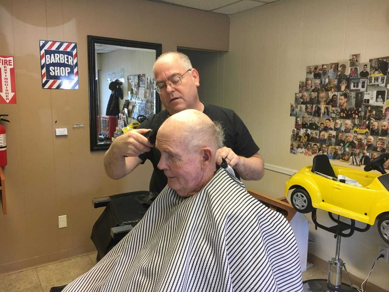 Owner Mark Young with customer Dan Keon, 80, who has been coming to the Buchanan Barbershop since it opened.