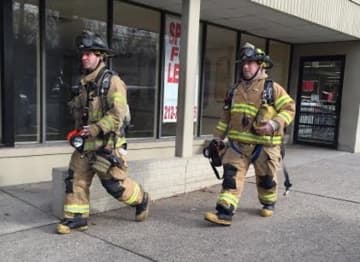 Teaneck firefighters exit Amazing Savings Tuesday morning after responding to a false alarm.
