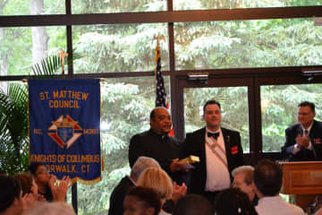 Knights Of Columbus Council 14360 Grand Knight presents a gift to the Rev. Reggie Norman after his Communion Breakfast talk.