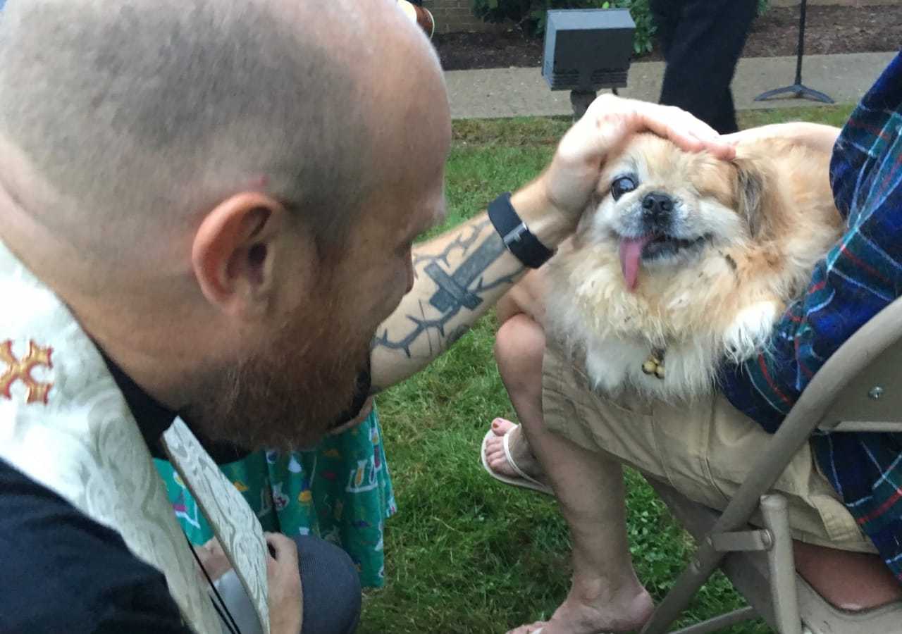 Rev. Andy Smith blesses Sushi the Pekingese, who is blind and deaf, at the Grace United Presbyterian Church's annual "Blessing of the Animals" Thursday.
