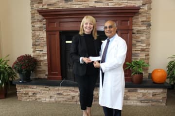 Dr. Hansraj Sheth, vice president of the medical staff, delivers check to Mary Young, CEO of the Red Cross Metro NY North chapter.