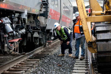 Rail workers inspect the area of the May 17 train derailment and collision along the Bridgeport/Fairfield border. 