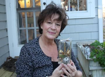 Laurie Davis displays one of this years 2013 ornaments outside her Wilton studio.