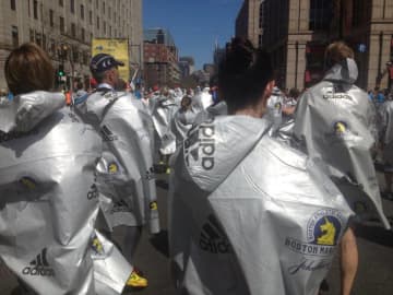 Runners in Monday's Boston Marathon wrap up in foil sheets at the finish line.