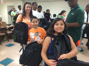 Vicki, left, Jack, center and Emma Bellescio, right, fill backpacks with school supplies for the less fortunate. 