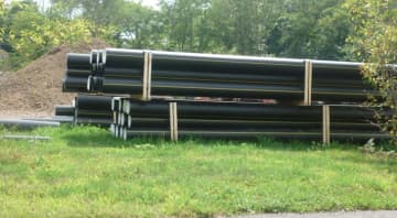 Pipe for the 3.5-mile gas pipeline in Wilton is stacked in a staging area. Work began in August and is expected to be completed by the end of November.