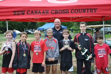 Coach Bill Martin celebrates with runners from the New Canaan Blazers youth cross country team after a strong performance at the Wilton Invitational.