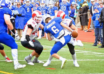New Canaan's Zach Allen (44) and Alex LaPolice tackle a Darien runner during a game on Thanksgiving. The Rams meet Wethersfield Saturday in the state tournament.