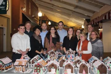 Volunteers from UBS helped make gingerbread houses at Waveny LifeCare Network in New Canaan. See story for IDs.