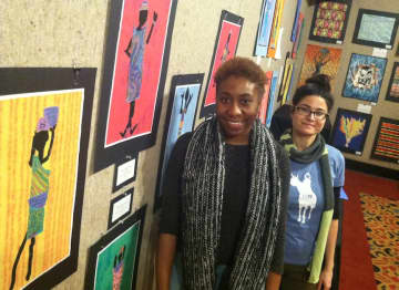 Kimberlyn McKoy, left, assistant curator for Picture That, and Liz Squillace, an assistant at Picture That, installing a show of student art work at the Palace Theatre. 