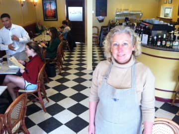 Café Ruche owner Barbara Chopin stands in her middle of her business as Brendon Ramsey helps with an order. The cafe opened in late December.