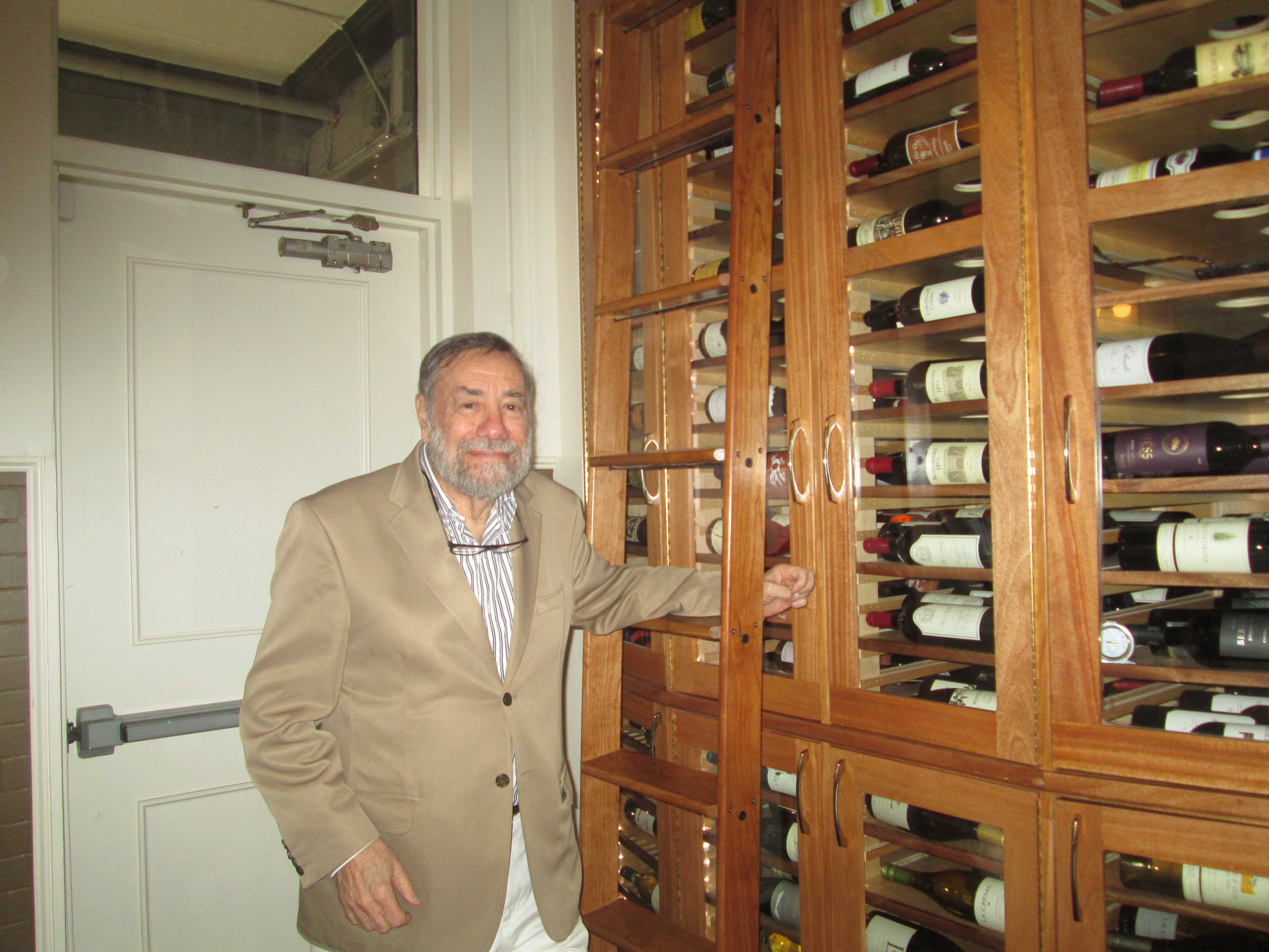 Andrew Economos in front of his wine cabinet at the Iron Horse Pleasantville.