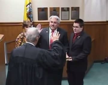 Tuckahoe Mayor Steve Ecklond takes his oath of office with the Rev. Eric Raaser of Immaculate Conception Church.